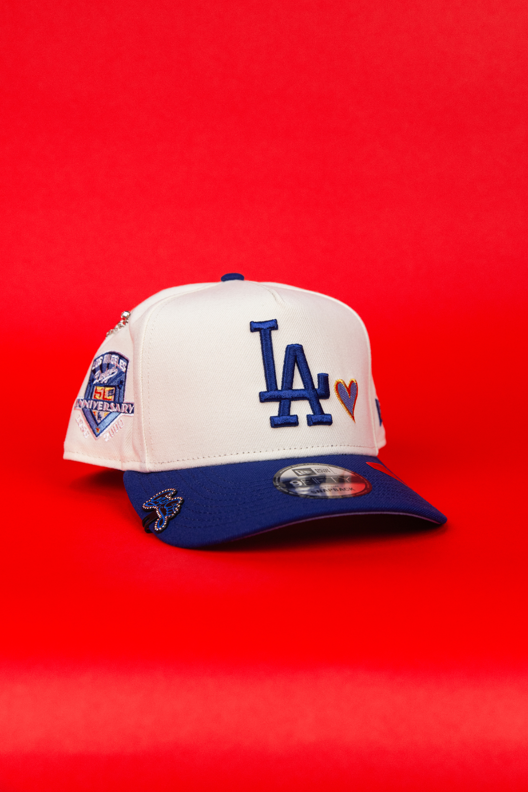 NEW ERA 9FIFTY A-FRAME CHROME/ BLUE LOS ANGELES DODGERS SNAPBACK W/ BLUE HEART + 50TH ANNIVERSARY SIDE PATCH